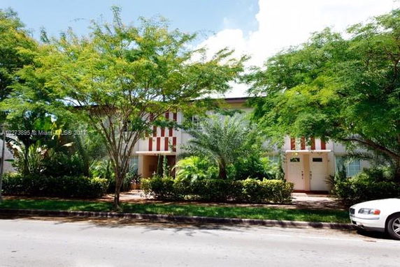 Front view of a two-story residential building with trees in front.
