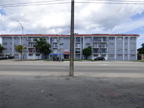 Front view of a multi-story apartment building with balconies.
