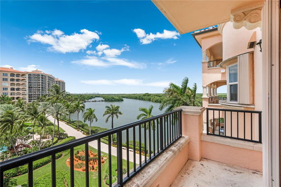 View from a balcony overlooking a body of water and surrounding buildings.