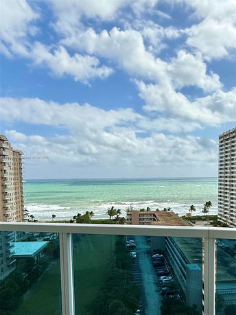 Wide-angle view overlooking buildings and the ocean from a high vantage point.
