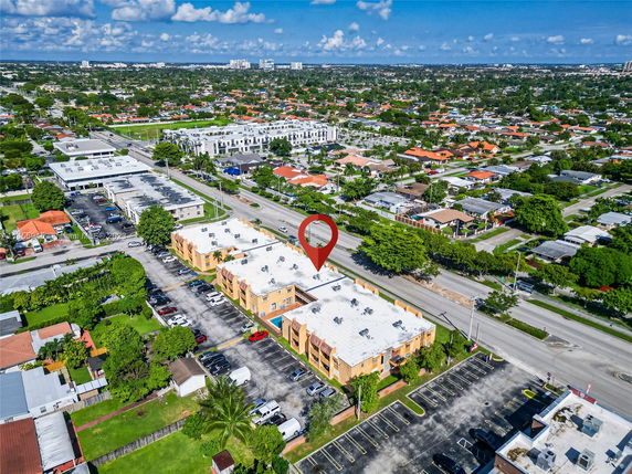 Aerial view of a residential area with multiple buildings and parking spaces.