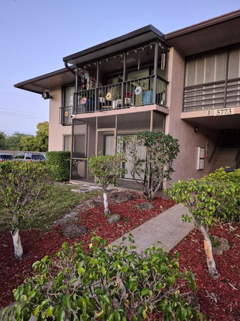 Front view of a two-story building with a balcony on the upper floor.