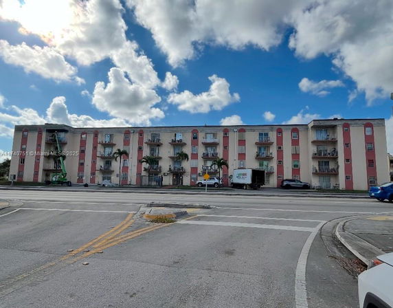 Front view of a multi-story apartment building with balconies.