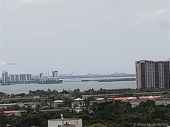 Wide angle view of cityscape with buildings and water in the background.