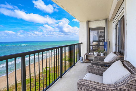 Balcony view of the beach with seating area.