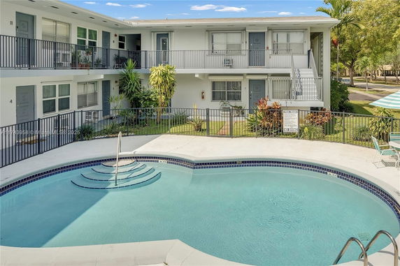 Outdoor swimming pool with apartments in the background.