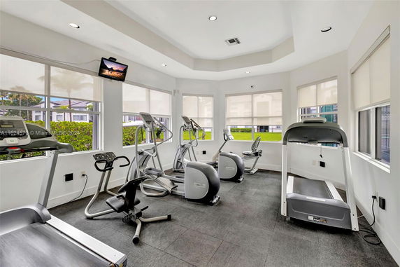 Interior view of a gym area with exercise equipment and window views.