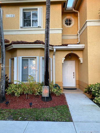 Front view of a two-story house with a yellow exterior and white door.
