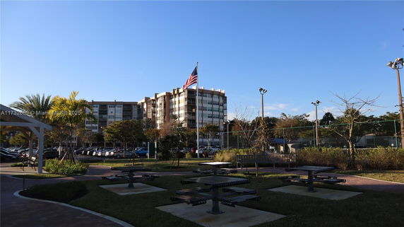 View of residential buildings with parking area and surrounding greenery.