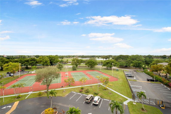 View of tennis courts and parking area in an open outdoor setting