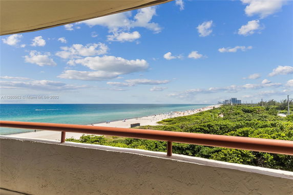 Panoramic view of a beach and ocean from a balcony.