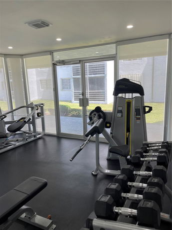 Interior view of a gym with various exercise equipment and weights.