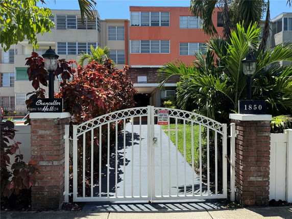 Front view of a multi-story residential building with gated entrance.