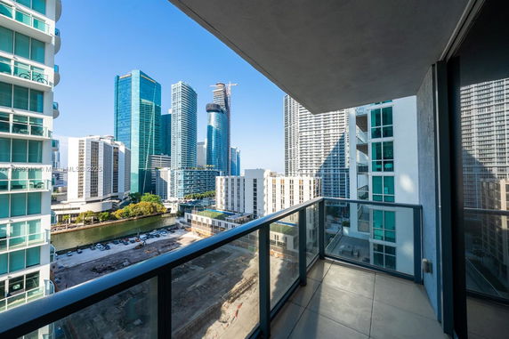 View from a balcony overlooking a city skyline with tall modern buildings.