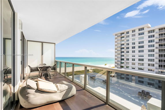 Balcony view overlooking the ocean and adjacent building.