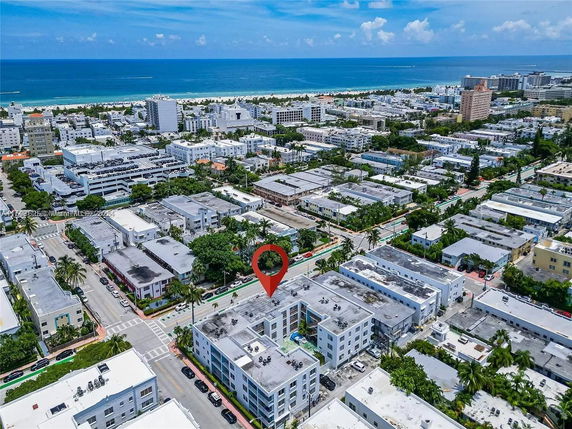 Aerial view of a coastal city area with multiple buildings and the ocean in the background.