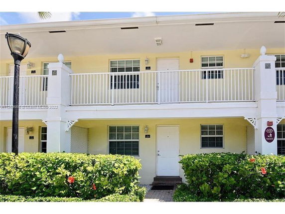 Front view of a two-story building with railing on the upper level balcony.