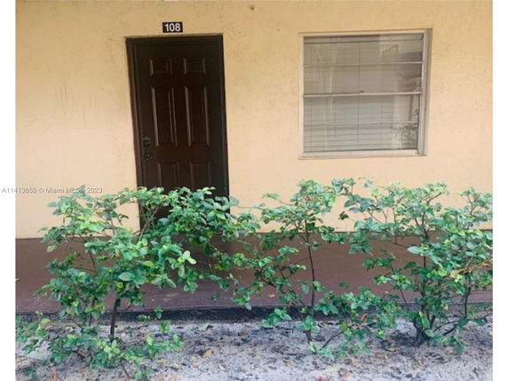 Front view of a building with a door and a window, labeled with number 108.