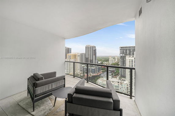 Panoramic view from a balcony with cityscape in the background.