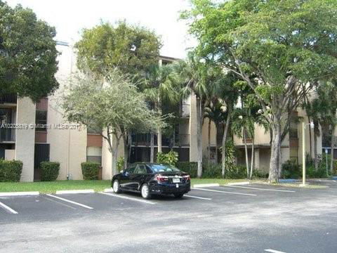 Outdoor parking area in front of a multi-story residential building.