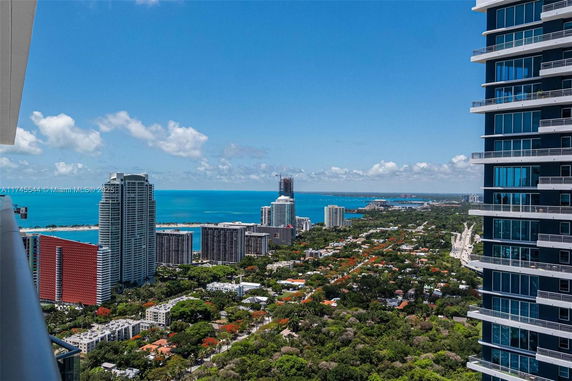 Panoramic view of a coastal city with high-rise buildings and ocean in the background.
