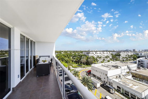 Balcony view of urban cityscape and palm trees.