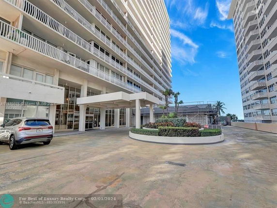 Front view of a tall multi-story residential building with balconies.
