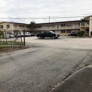 Front view of a two-story apartment building with a parking area.