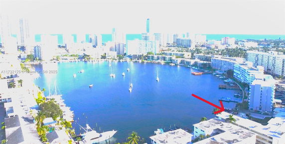 Panoramic view of a cityscape with water, buildings, and sailboats.