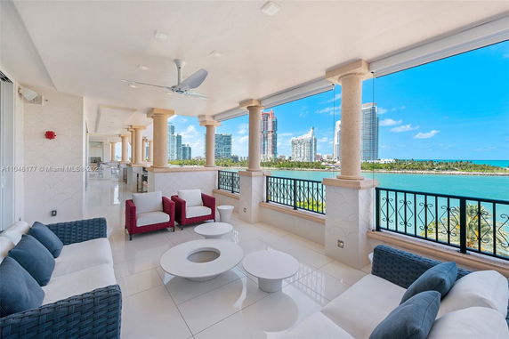 Outdoor balcony area with modern furniture and a panoramic view of the city skyline and waterfront.