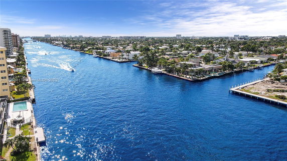 Panoramic view of a waterway with surrounding buildings and trees seen from above.