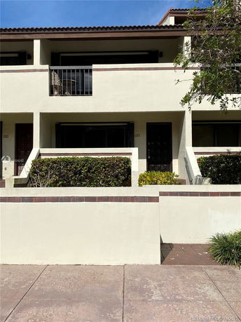 Front view of a two-story building with a balcony and entrance.