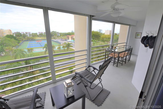 Balcony view overlooking tennis courts and surrounding greenery.