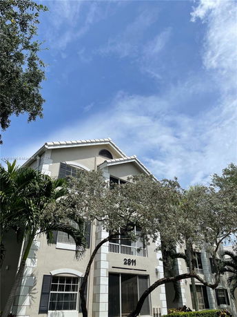 Front view of a multi-story building with trees in front.