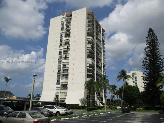 Front view of a tall residential building with multiple balconies.