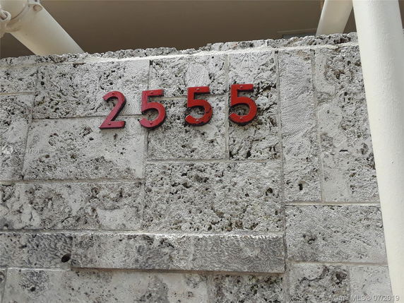 Close-up of a stone wall with the numbers 2555 mounted on it.