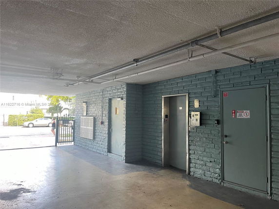 Covered parking area with an elevator and a door.