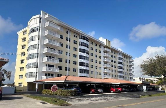 Front view of a multi-story apartment building with balconies.