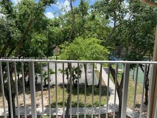 View from a balcony overlooking trees and a landscaped area.