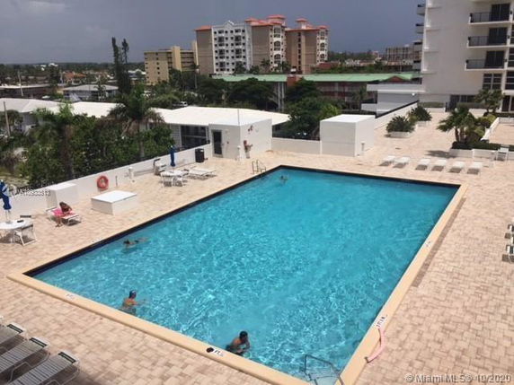 Outdoor swimming pool area with surrounding buildings.