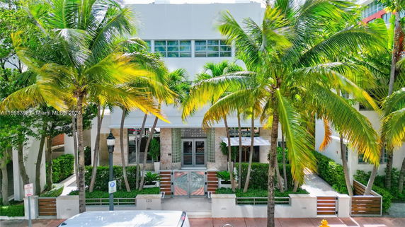Front view of a multi-story building with palm trees in front.