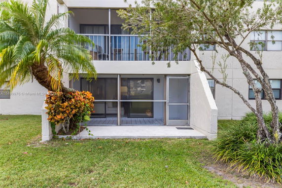Front view of a building with a screened patio and balcony.