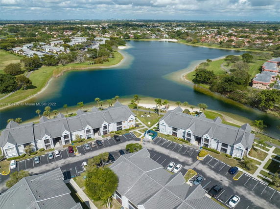 Aerial view of a residential area with townhouses near a large water body.