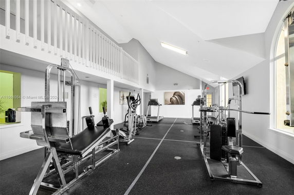 Interior view of a gym room with exercise equipment and a loft area.