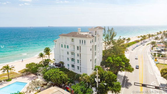 Front view of a multi-story coastal building near the beach.