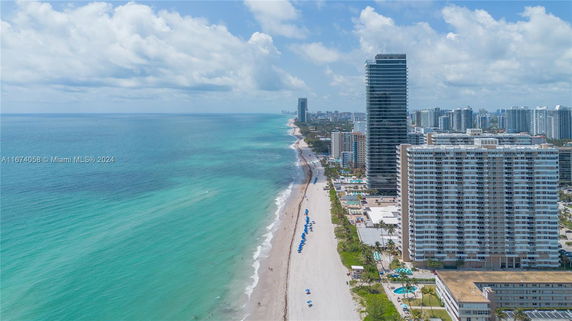 Panoramic coastal view with high-rise buildings and a sandy beach.