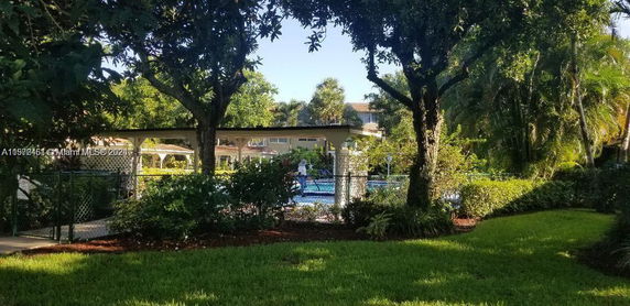View of an outdoor swimming pool surrounded by trees and vegetation.