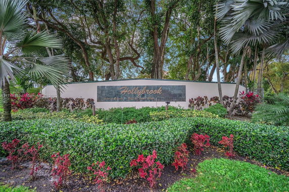 Entrance sign of Hollybrook surrounded by lush greenery and trees.