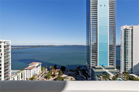 View of a cityscape with high-rise buildings and a large body of water.