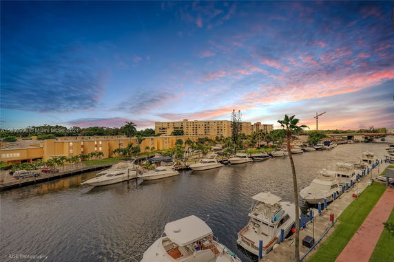 View of residential buildings near a waterfront with boats docked along the pier.